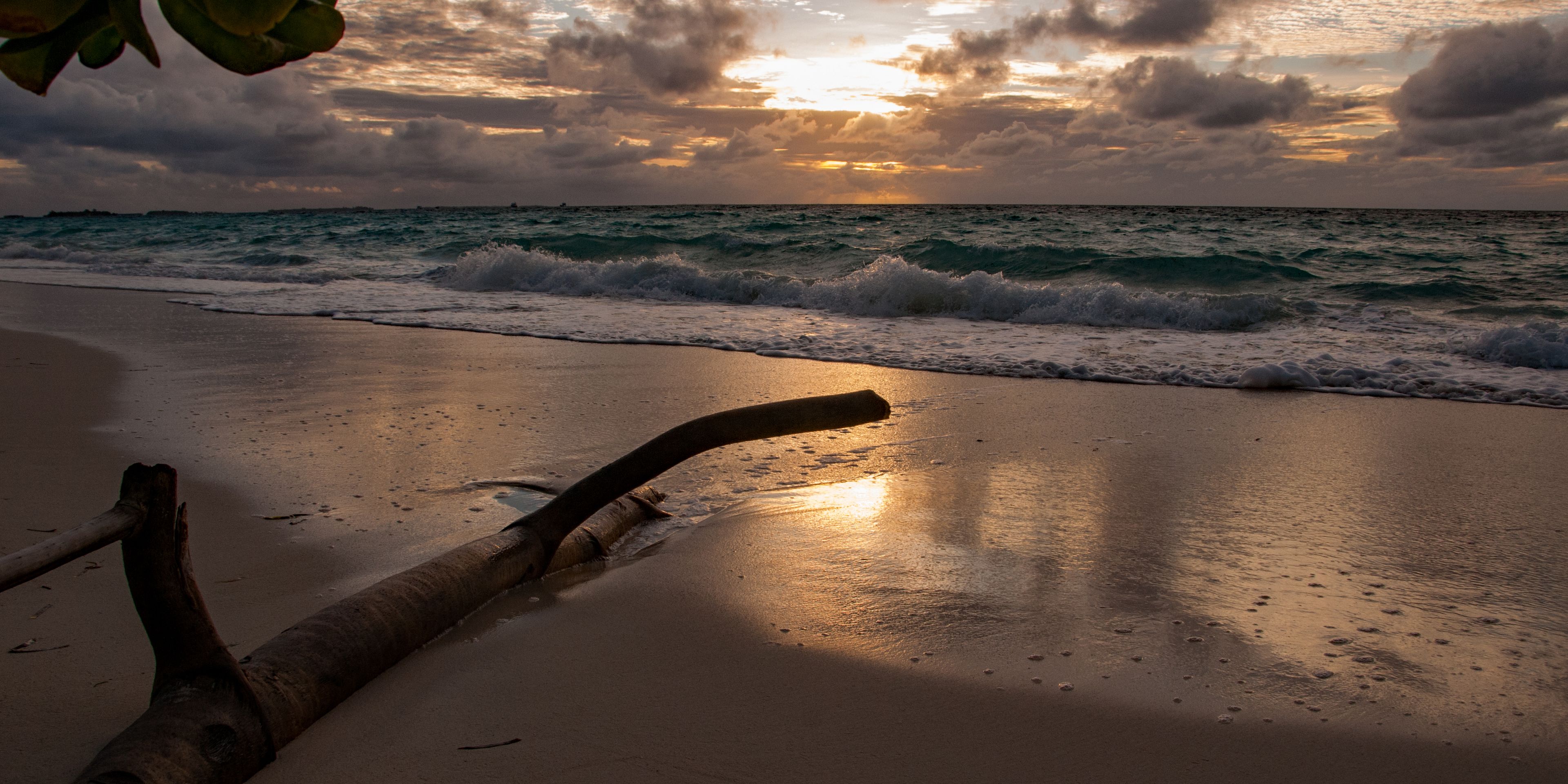 Die Meeresbrandung am Strand von Dhigurah im Sonnenuntergang