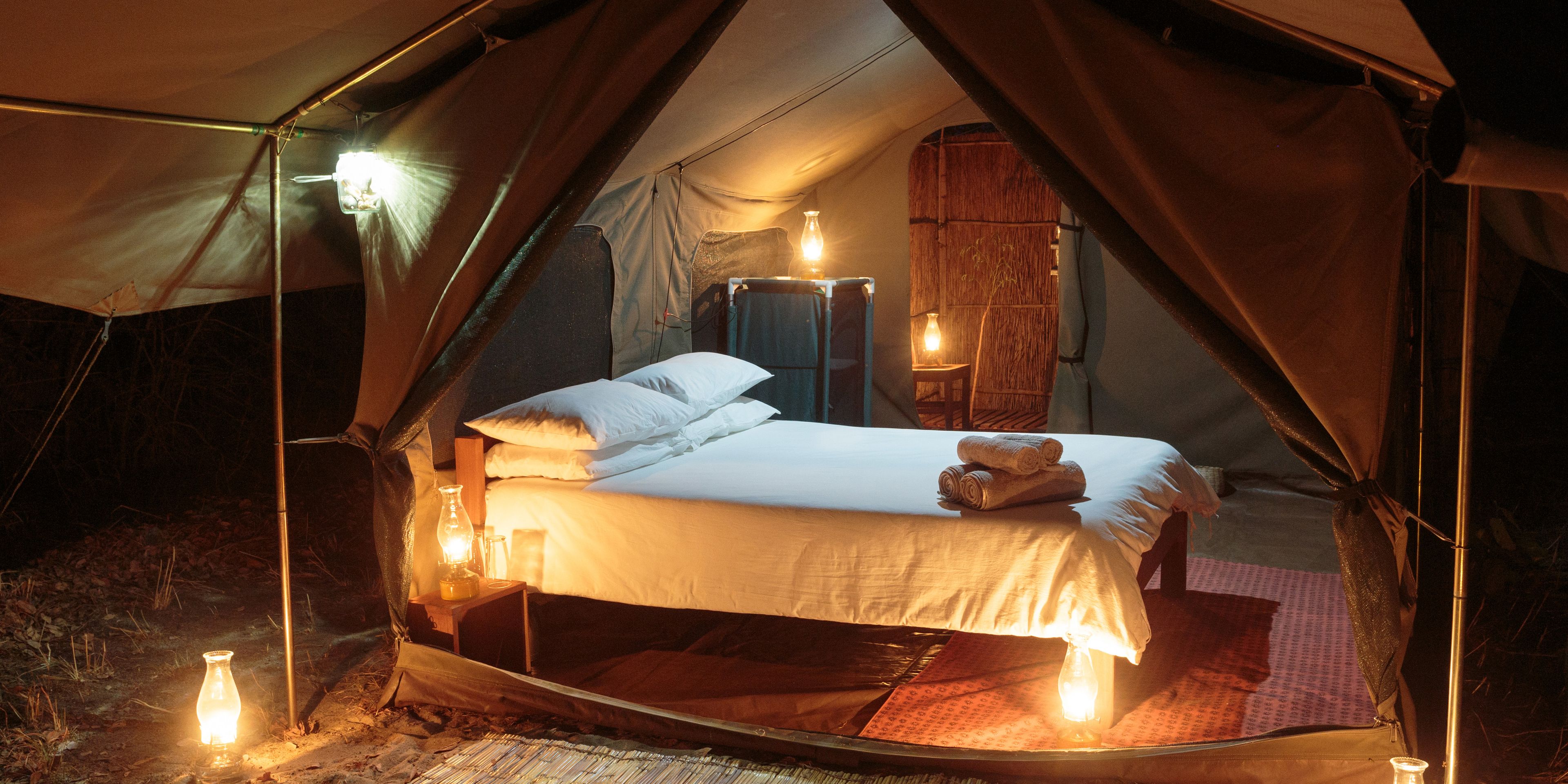 Ein gemuetliches Doppelbett in einem Hauszelt dient als Schlafplatz