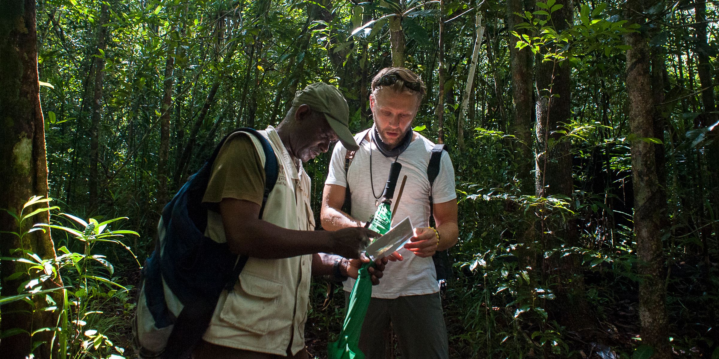 Two men navigating through the rainforest