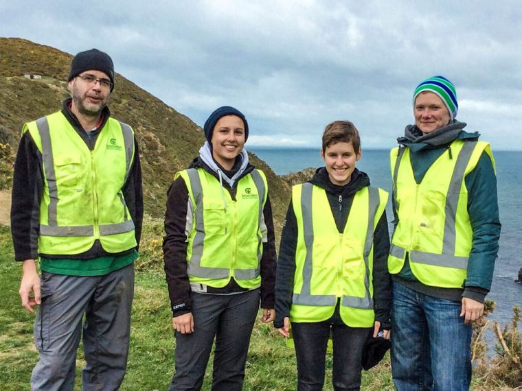 Die Freiwilligen stehen an der Kueste Neuseelands als Gruppe zusammen