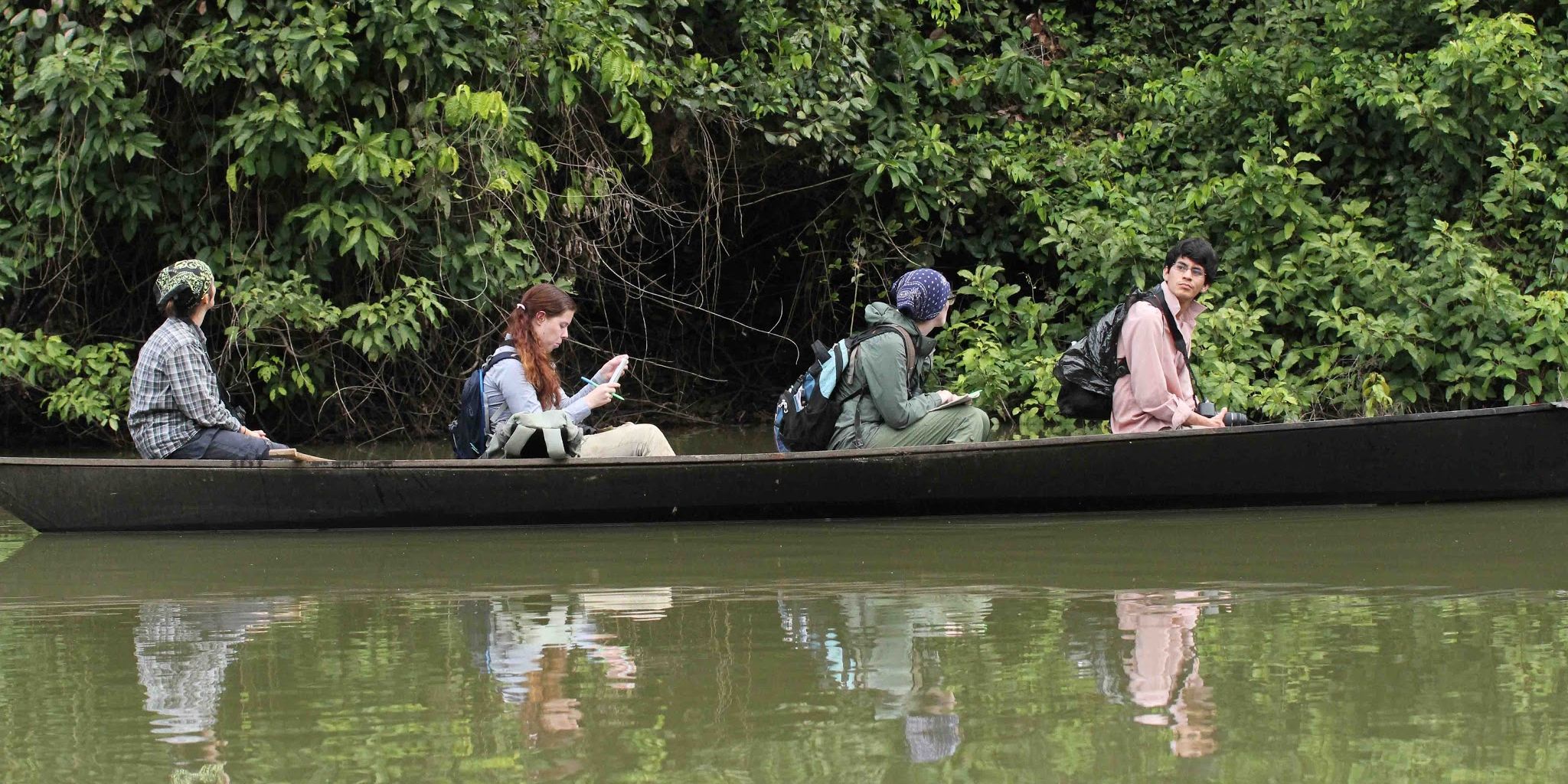 Eine Gruppe von Studenten bei einer von einem Ranger gefuehrten Bootstour durch den Amazonas