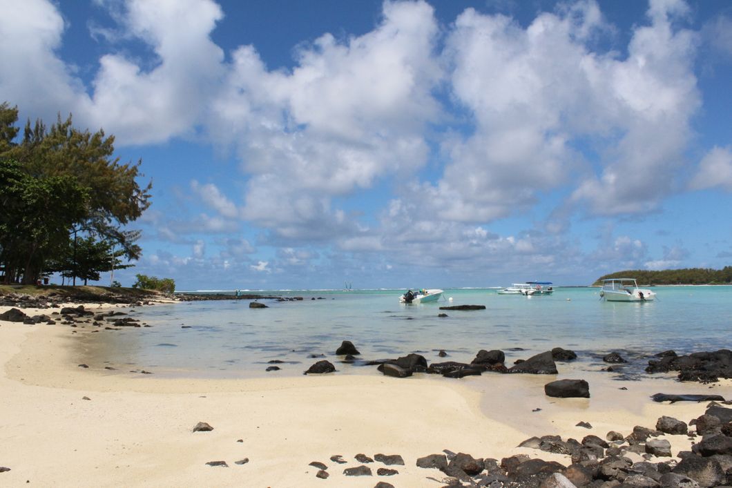 Standing on a beach in Mauritius, looking over the blue Indian Ocean