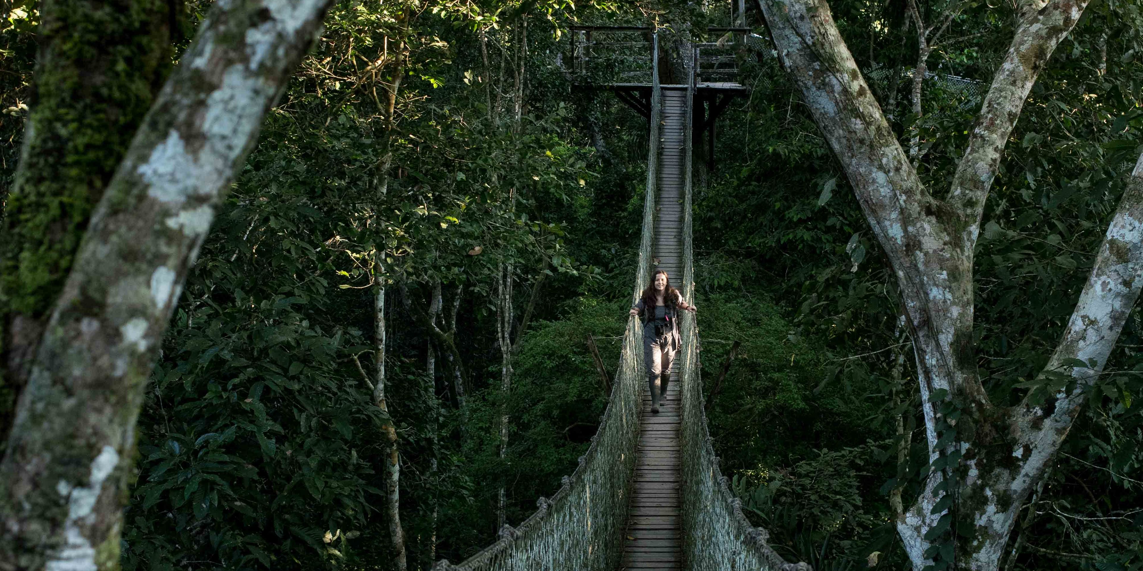 Ein Student eines Rangerkurses laeuft ueber eine Haengebruecke im Regenwald