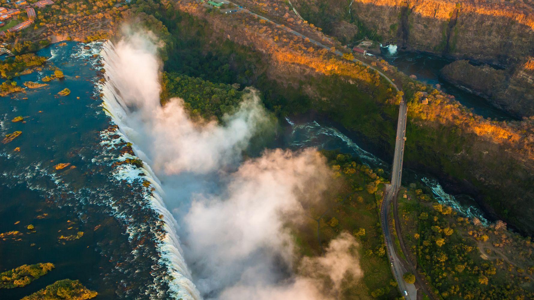 Die Victoriafaelle leuchten im Abendrot der untergehenden Sonne