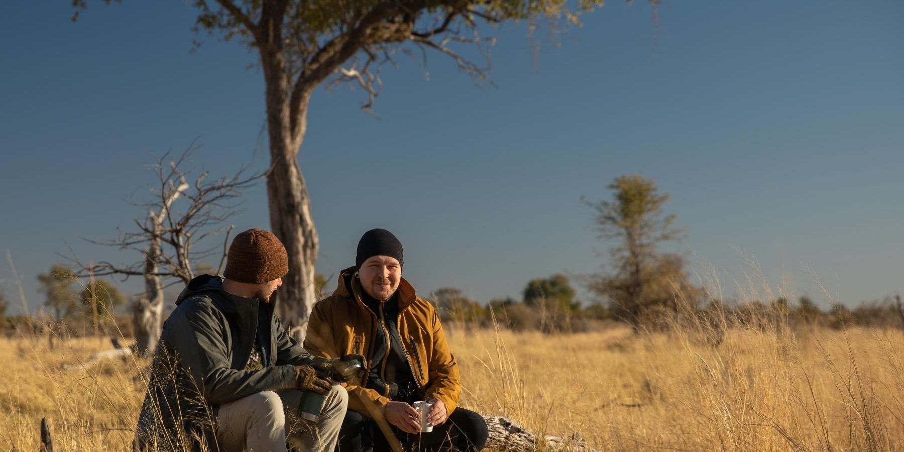 Zwei G&auml;ste unserer Private Wilderness Experience machen eine Pause unter einem Baum auf einer Walking Safari im suedlichen Afrika