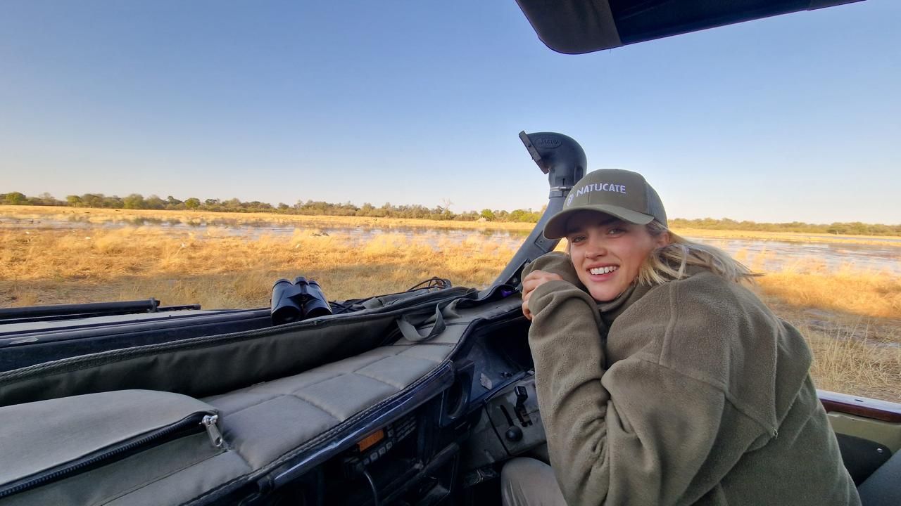 Frau l&auml;chelt sitzend im Auto im Okavango Delta