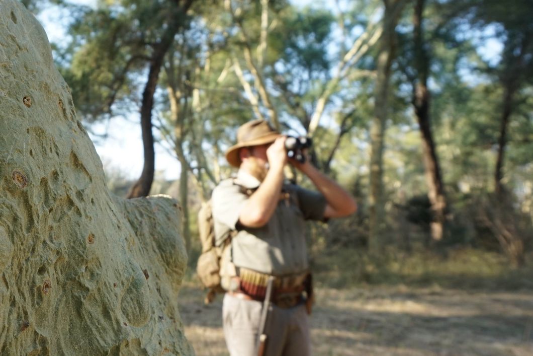 Ein angehender Ranger haelt im suedafrikanischen Busch Ausschau nach Tieren