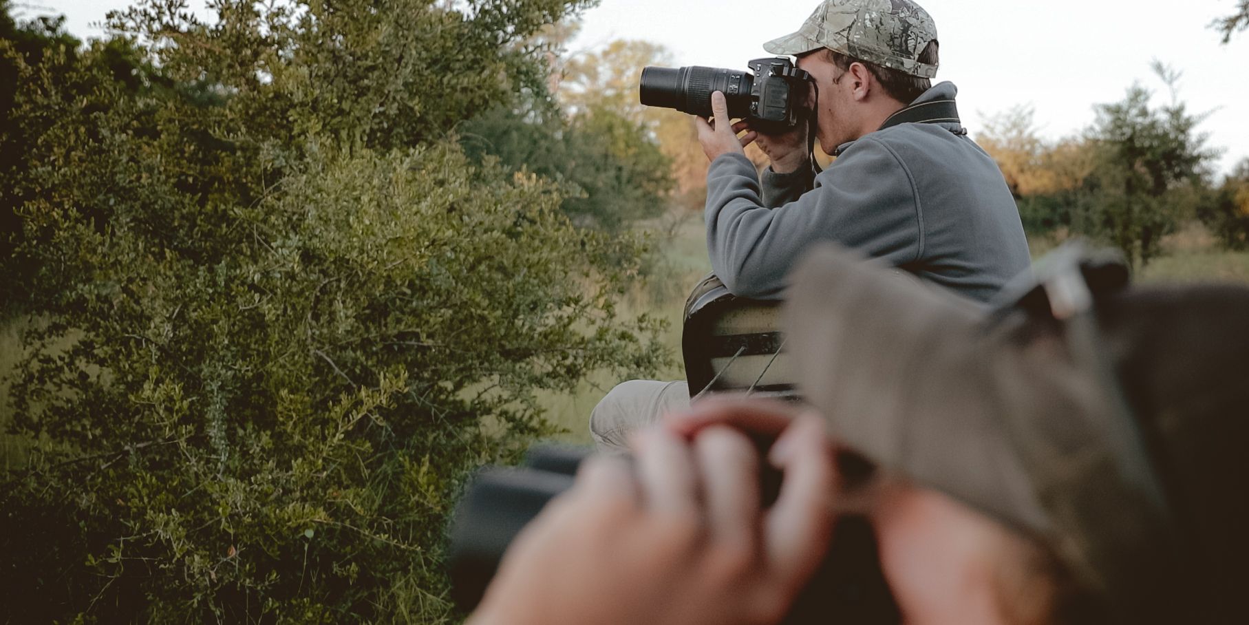 Teilnehmer des Natur- und Rangerkurses in Botswana beobachten bei einer Pirschwanderung Tiere im Busch