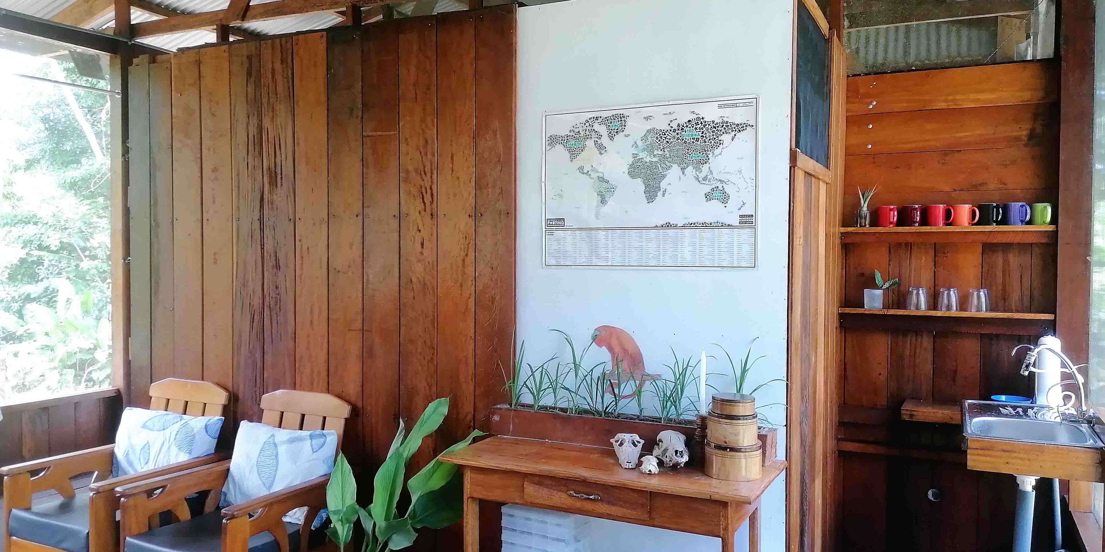 Der Gemeinschaftsraum der biologischen Station in Peru verfügt über Stühle, Pflanzen, eine Karte und einem Zugang zur Küche.
