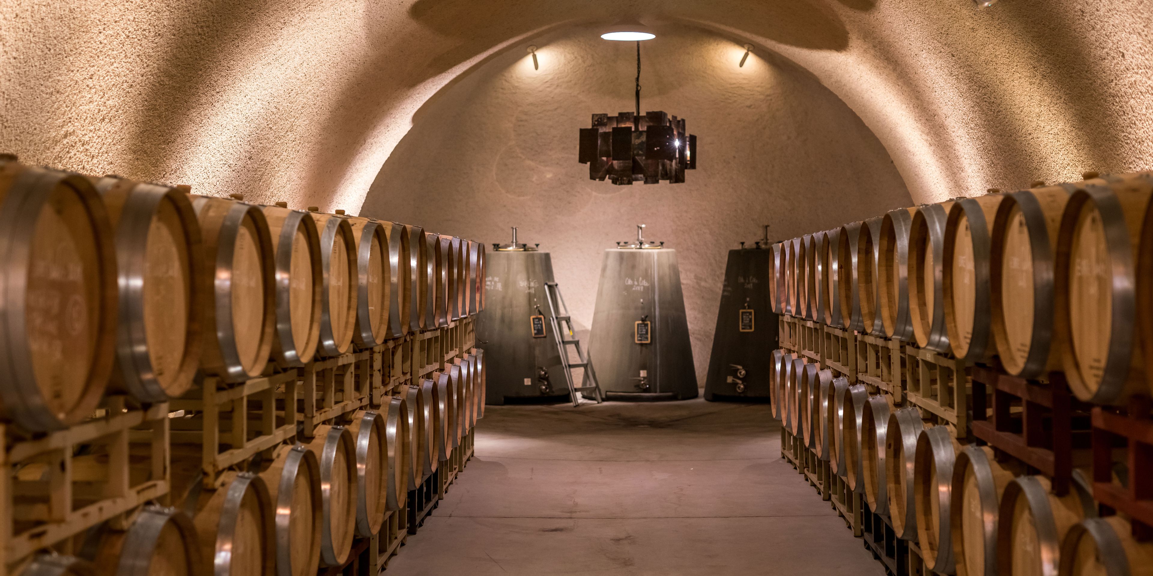 Blick in einen mit Faessern befuellten Weinkeller einer Winzerei in Kalifornien