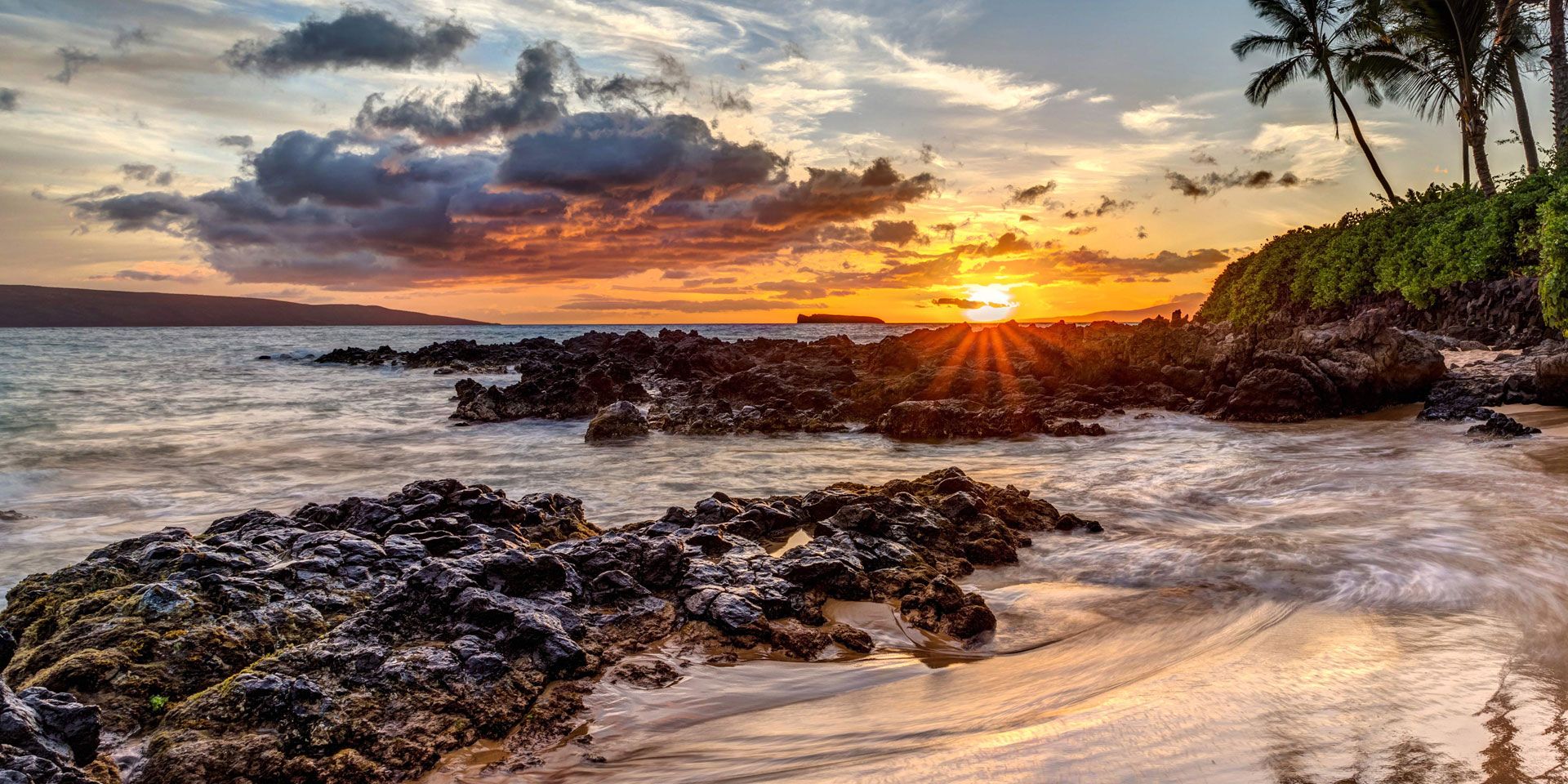 Conservation work in the USA: Hawaii's volcanic rocks in the breaking waves at sunset