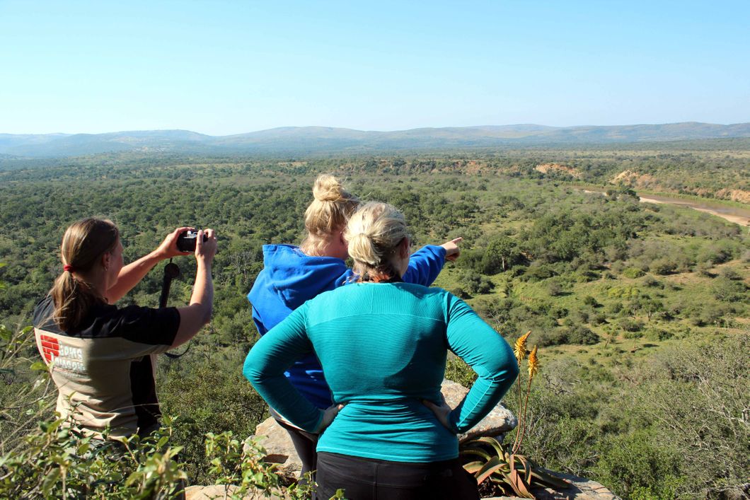 Teilnehmer unseres Artenschutz-Trainingskurses stehen in der Savanne KwaZulu-Natals und ueberblicken die Landschaft