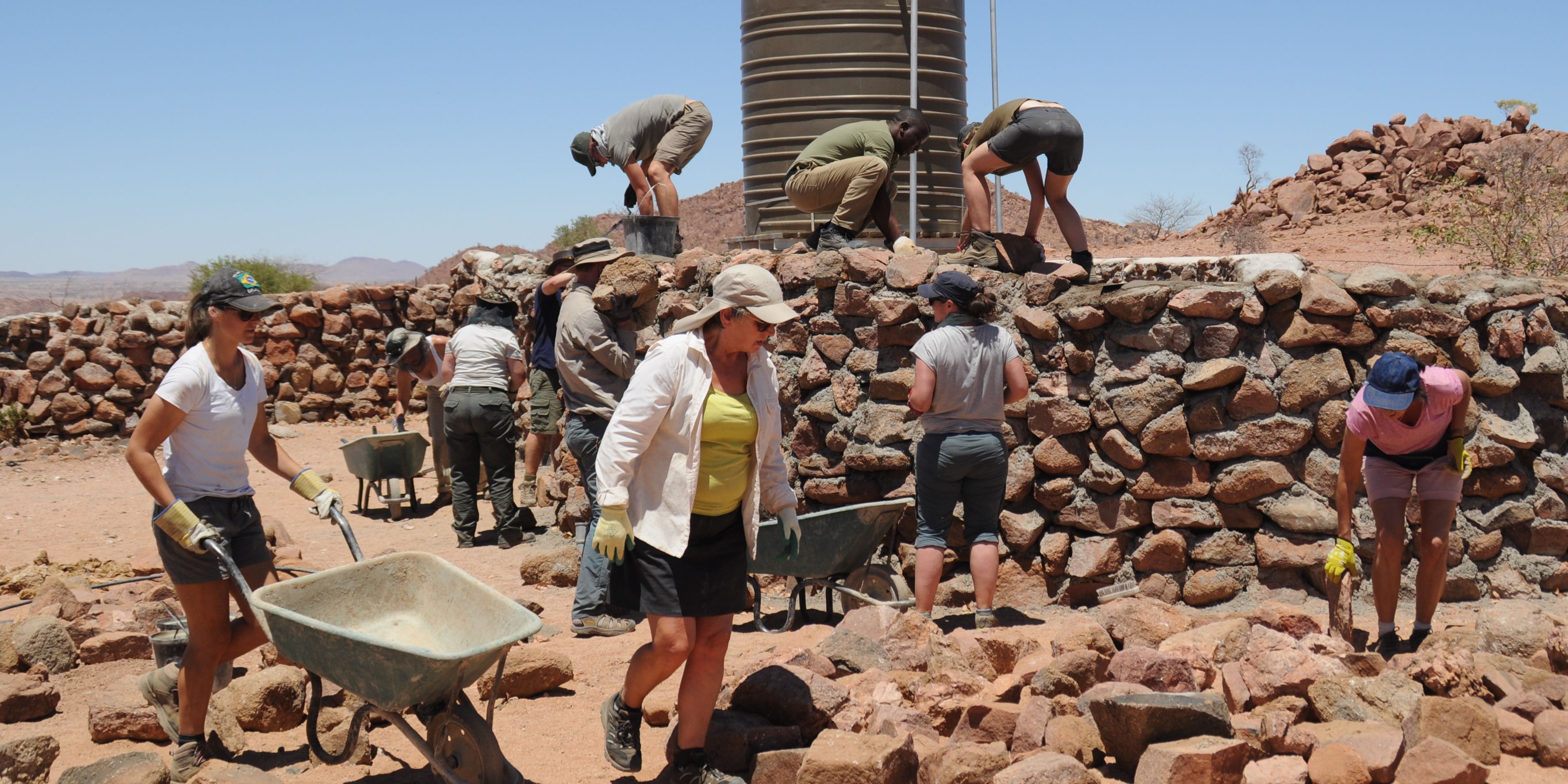Volunteers widmen sich in Namibias Damaraland gemeinsam der Errichtung von Schutzmauern.