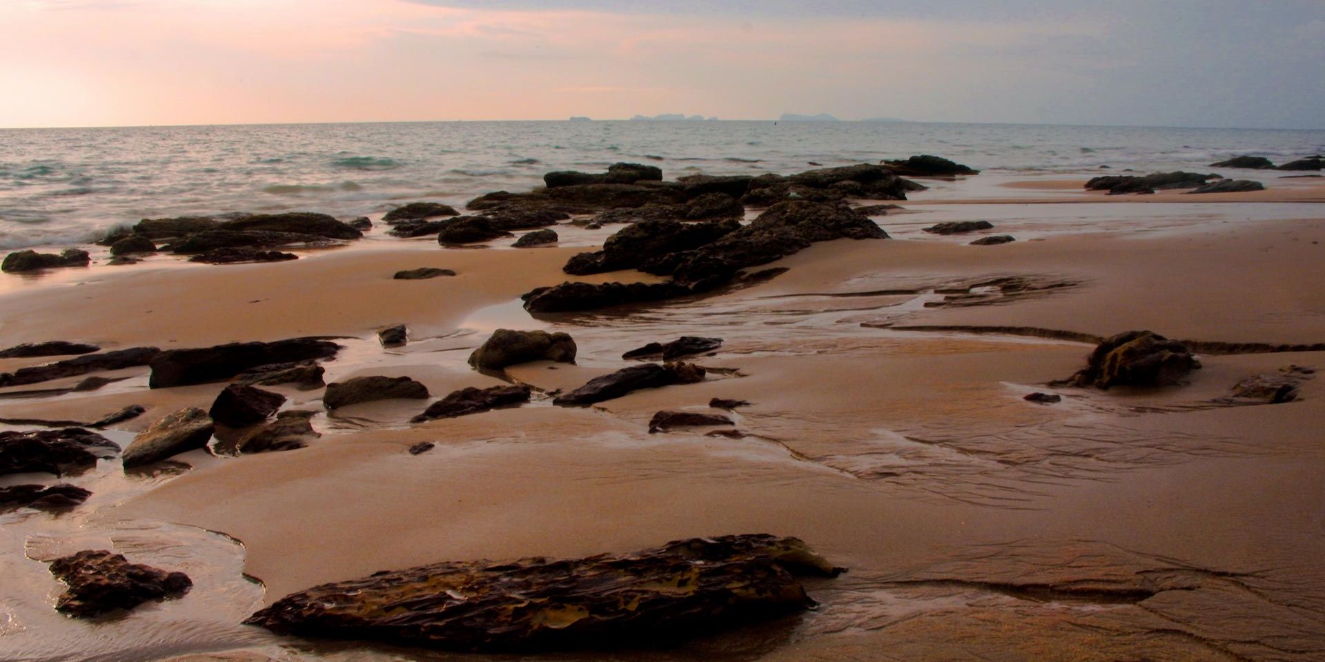 Blick ueber einen Strandabschnitt in Thailand im Licht der untergehenden Sonne