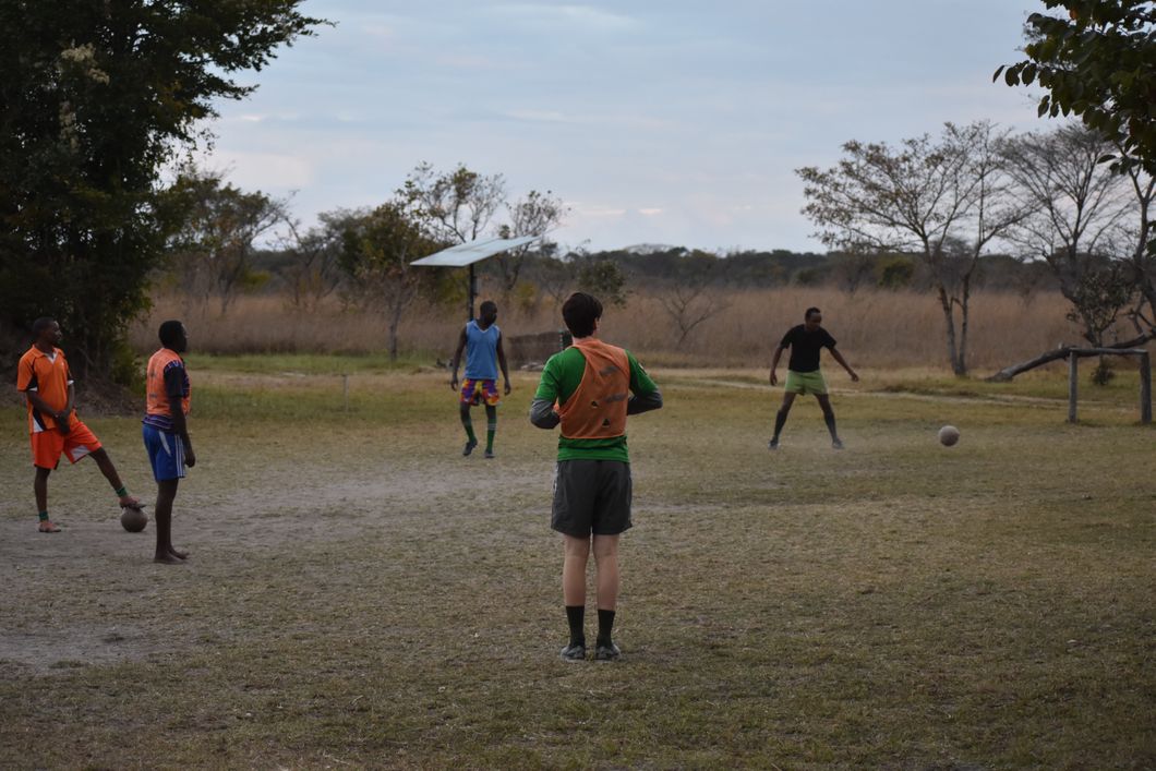 Freiwilligenhelfer des Elefantenprojekts in Sambias Kafue Nationalpark spielen im Camp zusammen Fussball