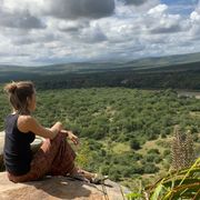 Nellie sitzt in Zululand am Rande einer Klippe und hat eine tolle Aussicht über die Weite Natur