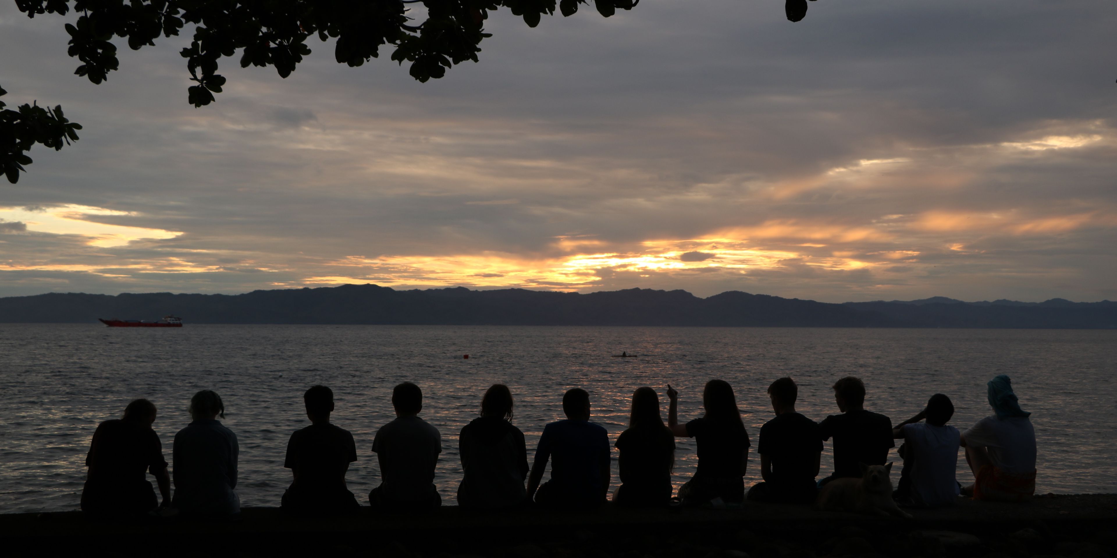 Volunteers in the Philippines are watching the sunset near the coast