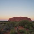 Freiwilligenarbeit in Down Under: Der Ayers Rock oder Uluru leuchet rot in der Ferne des Outbacks.