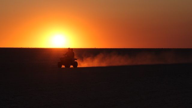Quadbike-Fahrt Afrika: Safari-Gaeste auf einem Quadbike bei Sonnenuntergang auf den Makgadikgadi Salzpfannen
