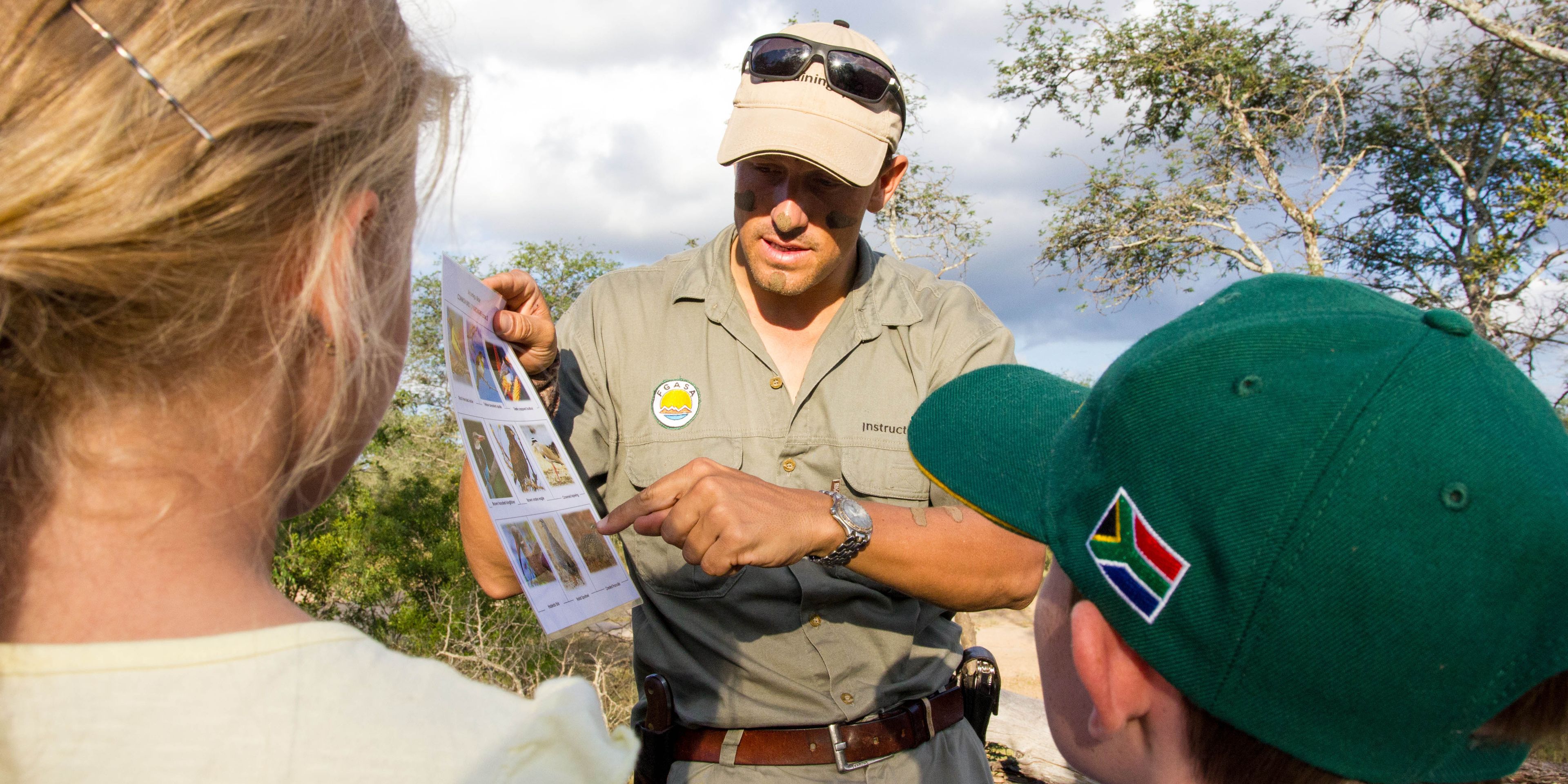 Ein Guide erklaert zwei Kindern die bekanntesten Vogelarten Suedafrikas