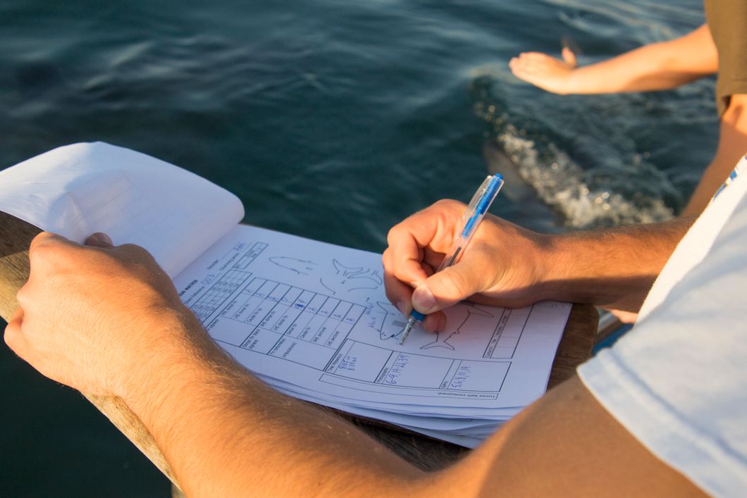 An intern in South Africa is collecting data while on the research boat