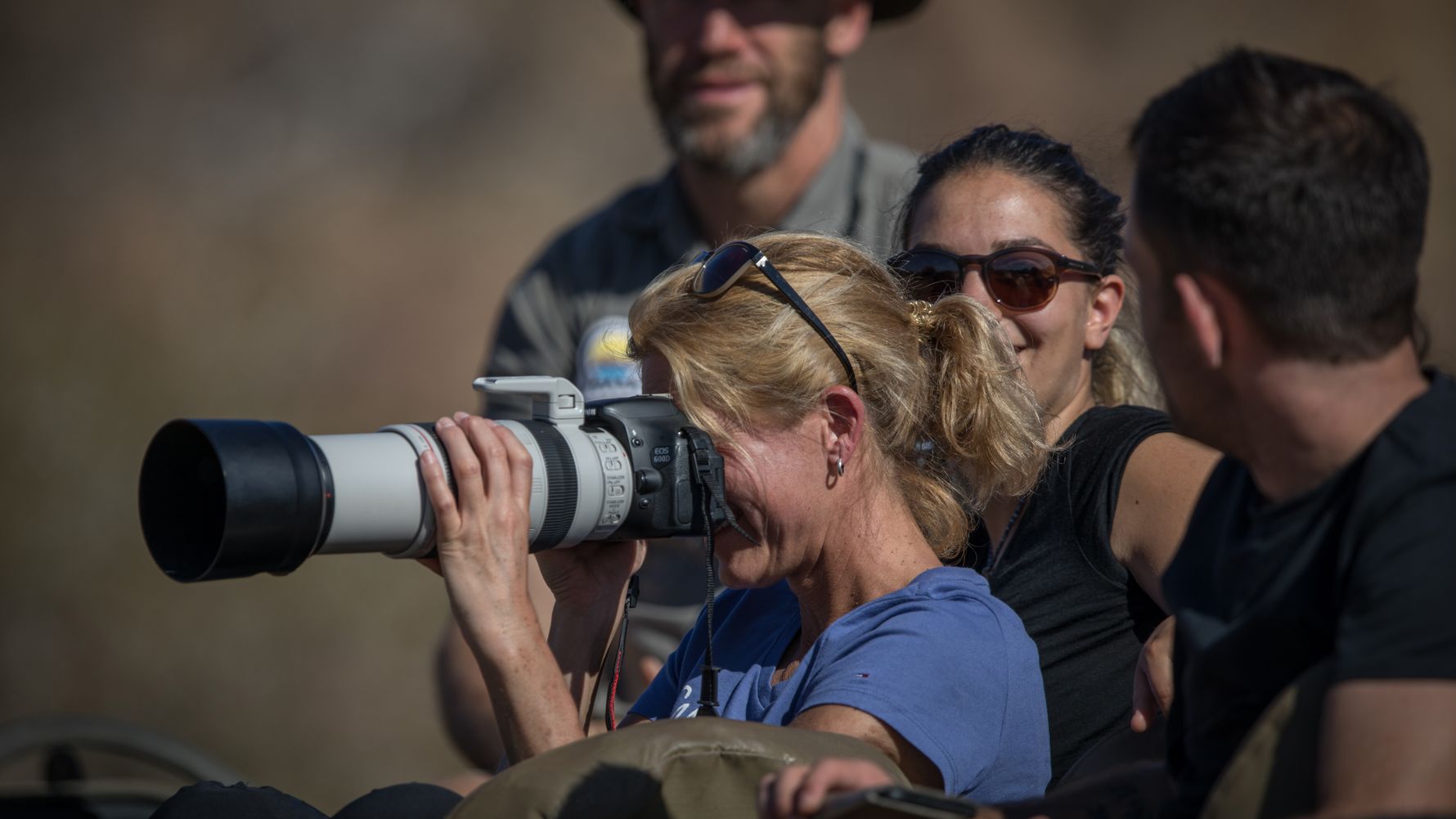 Fotosafari Afrika: Safari-Gast mit grosser Kamera fotografiert eine Wildlife-Szene im suedlichen Afrika
