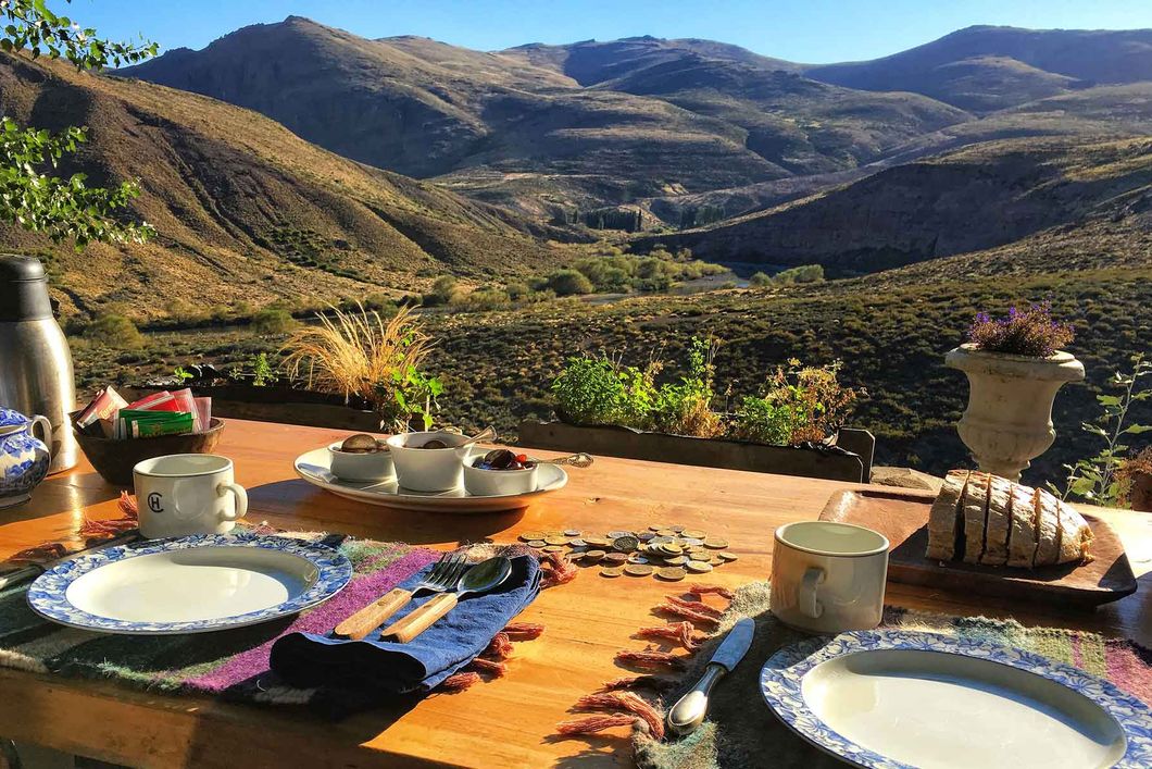 Die Praktikanten der Pferderanch fruestuecken bei einem wunderschoenen Ausblick ueber die Anden