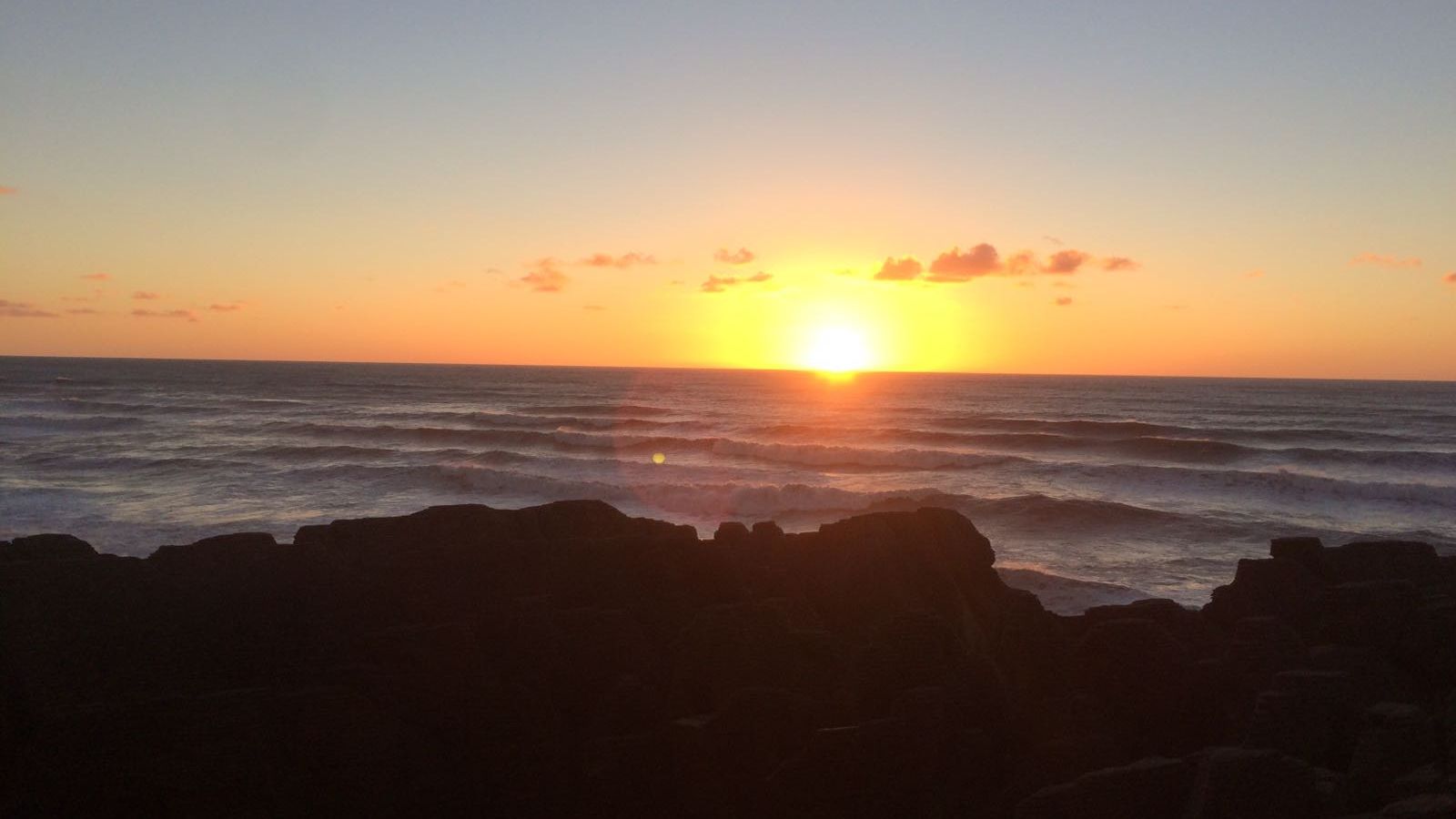 Ein Sonnenaufgang am Horizont des Pazifiks vor Neuseelands Kueste