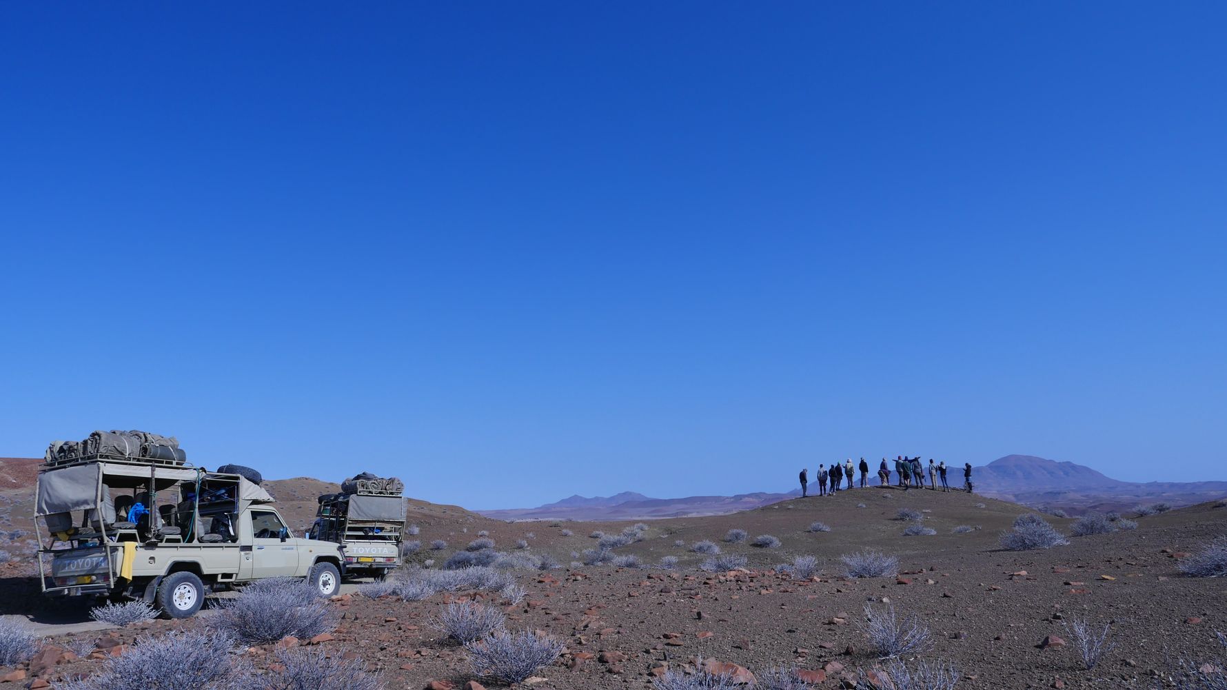 Mehrere Volunteere stehen auf eine Bergkuppe