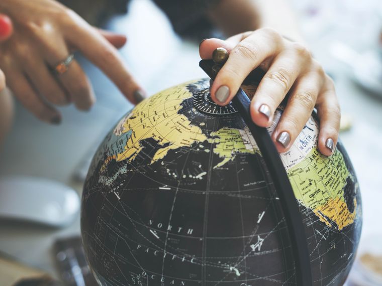 Nachhaltiges Reisen: Frau beschaeftigt sich mit einem Globus
