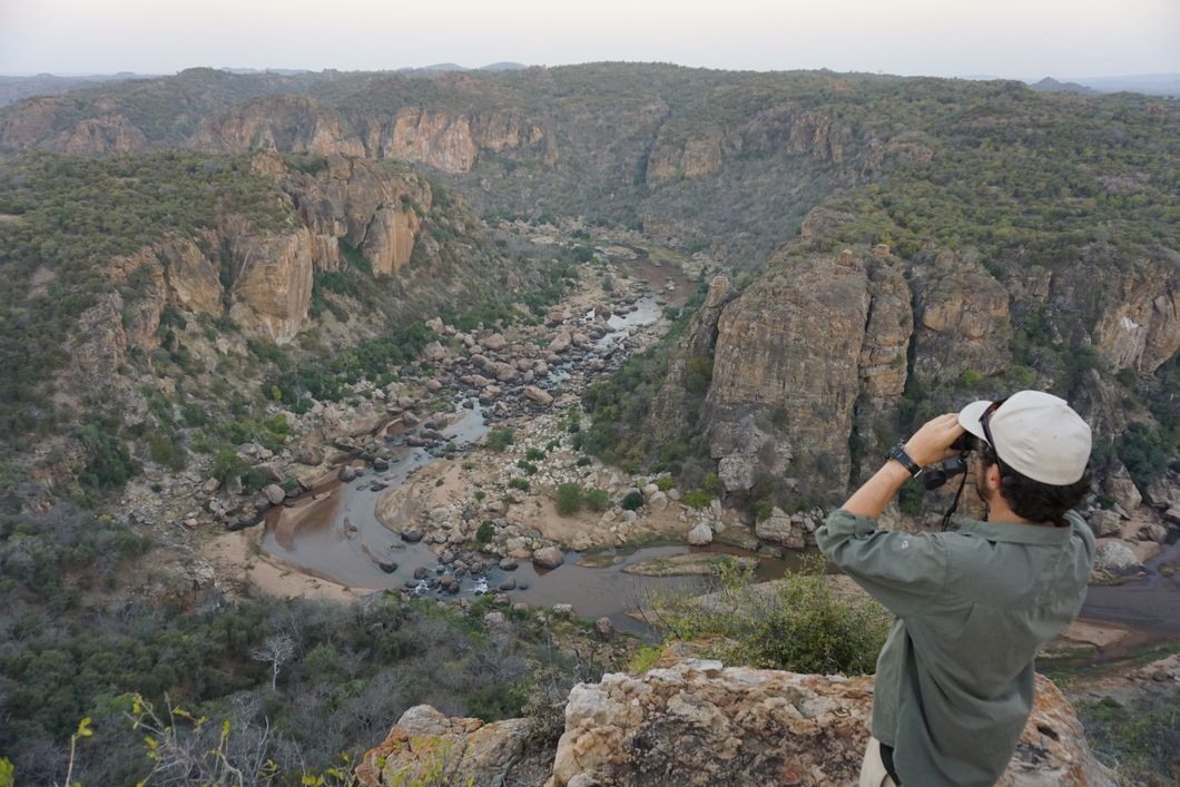 Ein Teilnehmer des Natur- und Rangerkurses fotografiert ein Flussbett in Afrikas Wildnis
