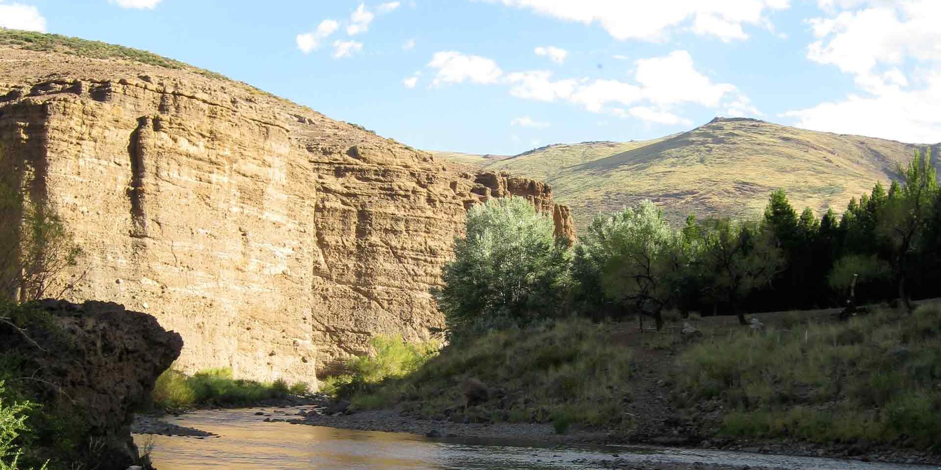 Ein Fluss schlaengelt sich durch das Tal eines Gebirges