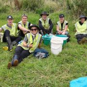 Freiwilligenarbeit in Neuseeland: Mehrere Volunteers legen eine Pause auf einem Feld ein