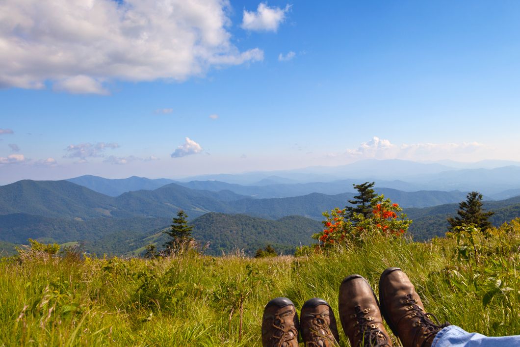 Looking over North Carolina's wooded hills; two volunteer's feet in the foreground