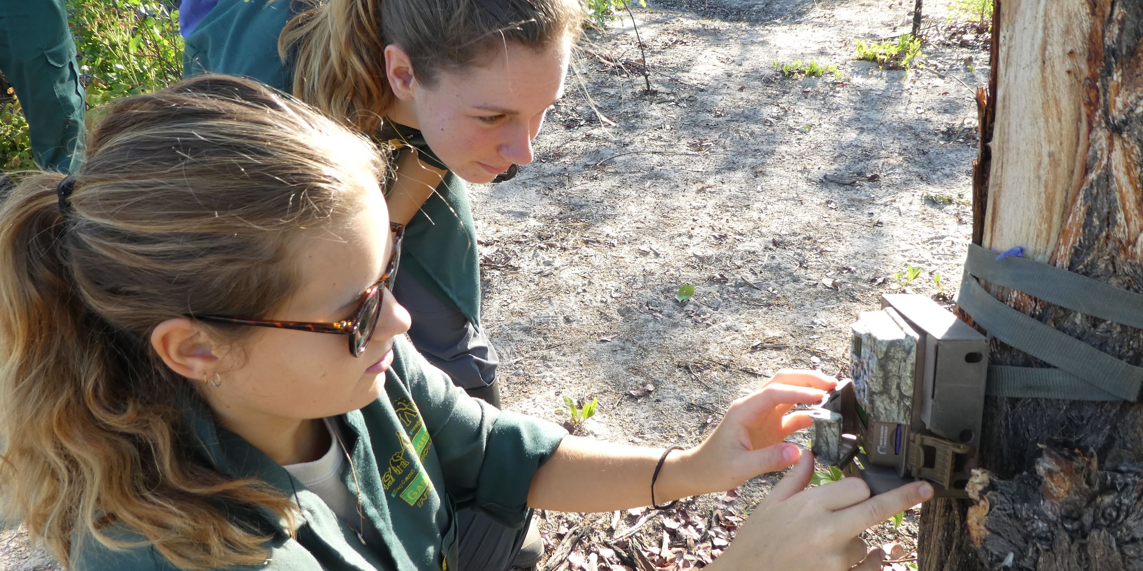 Zwei Freiwillige des Elefantenprojekts in Sambia installieren eine Kamerafalle im Kafue Nationalpark