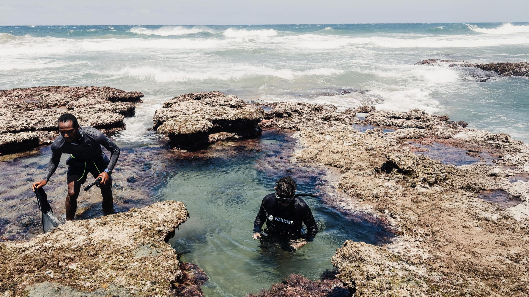 Rock pools with two snorkelling people at the Wild Coast