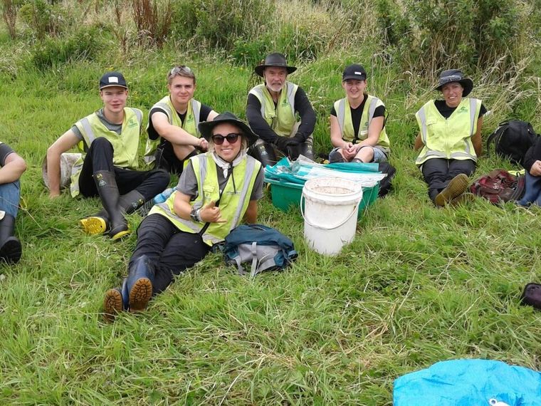 Freiwilligenarbeit in Neuseeland: Mehrere Volunteers legen eine Pause auf einem Feld ein