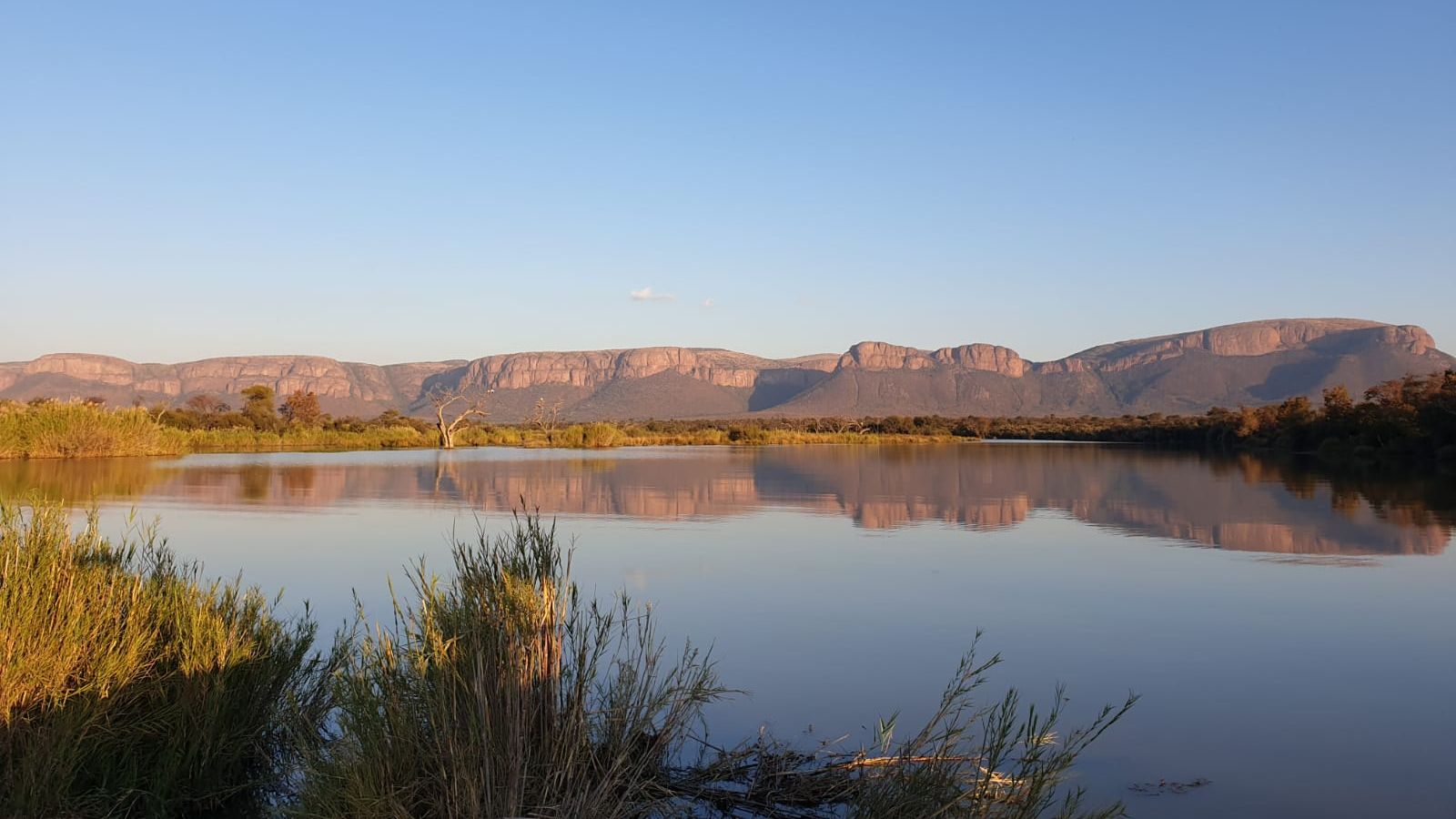 Safari-Reise Suedafrika: Blick &uuml;ber eine Landschaft mit See und Bergmassiv in Suedafrika