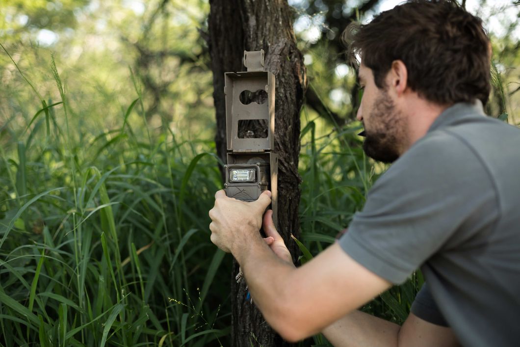 Ein Teilnehmer unseres Trainingskurses zum Wildlifeschutz in Suedafrika installiert eine Kamerafalle im Reservat