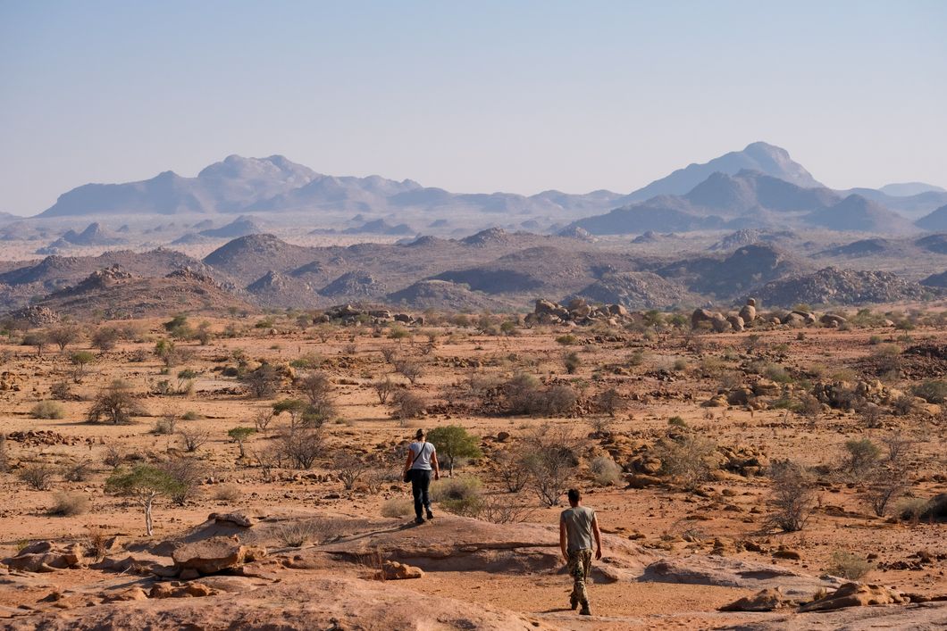 People walking through rocky desert