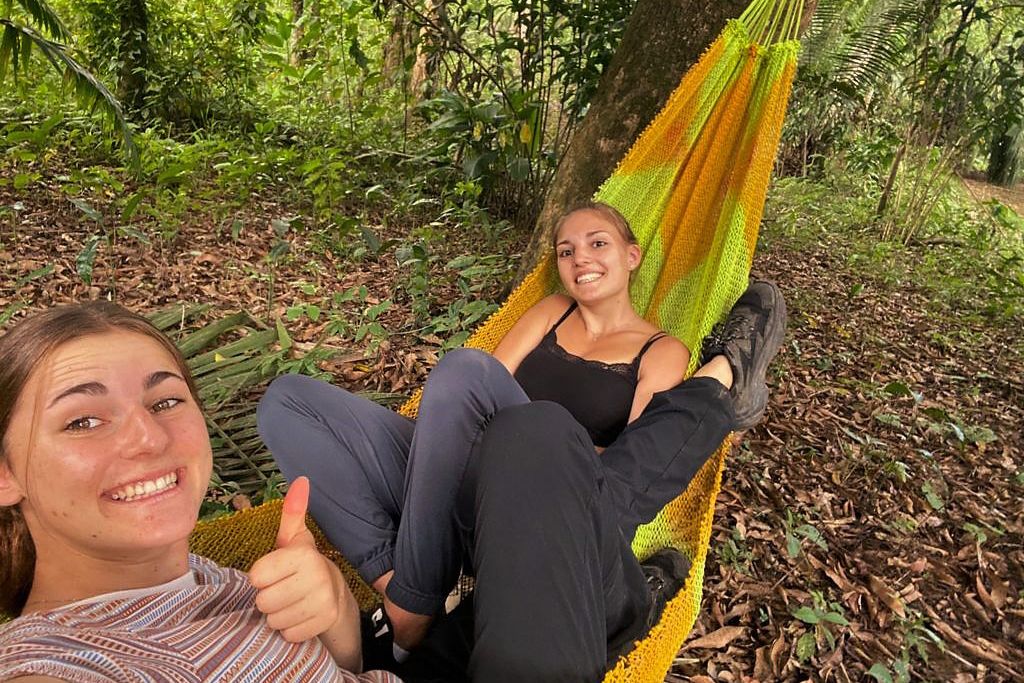 Zwei Freiwilligenhelferinnen der Forschungsstation in Peru verbringen ihre Freizeit gemeinsam in einer der Hängematten.