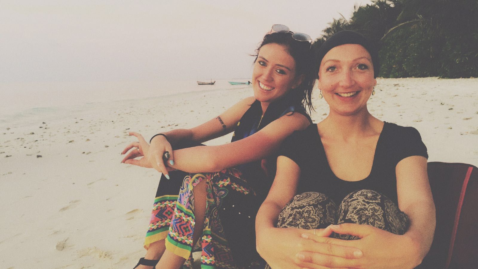 Zwei Volunteere sitzen am Strand auf den Malediven