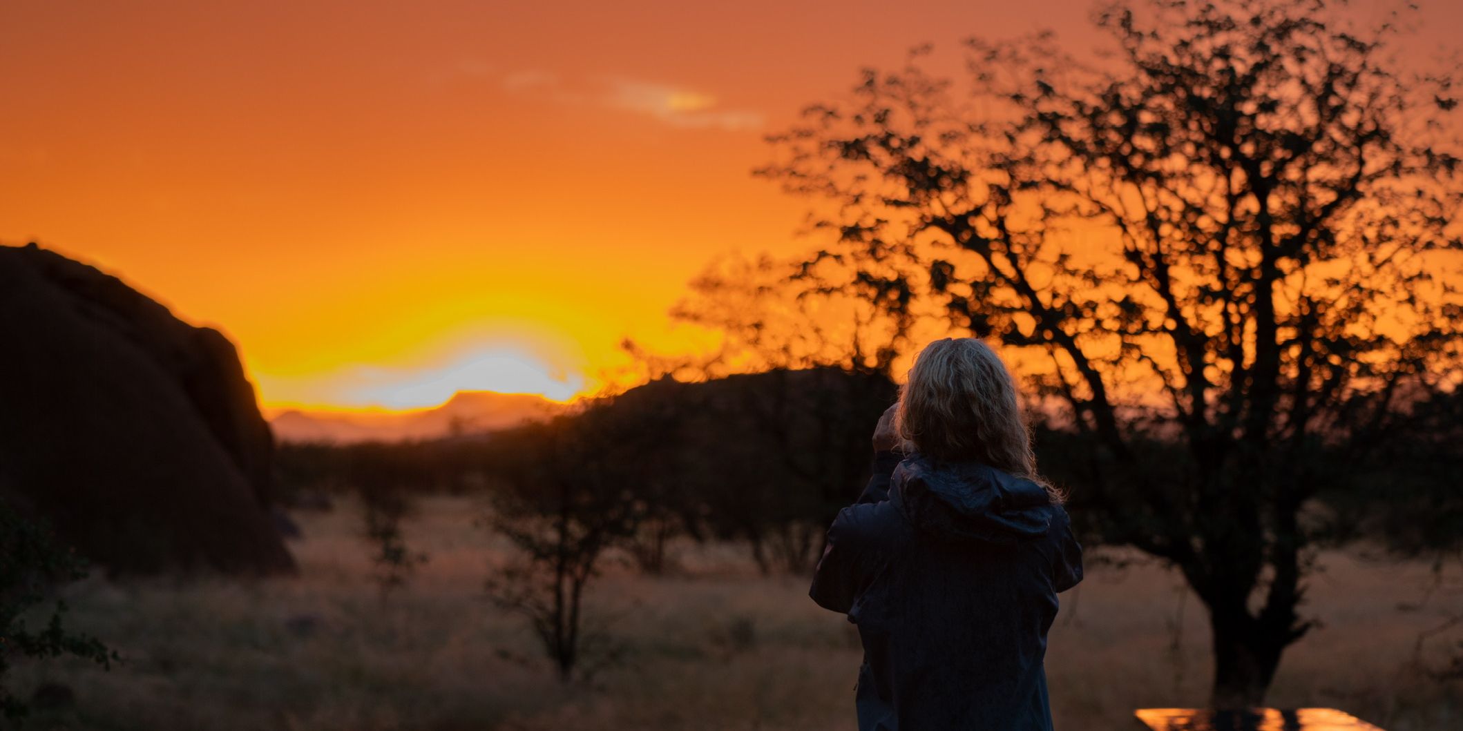 A woman watches the sunset in Namibia