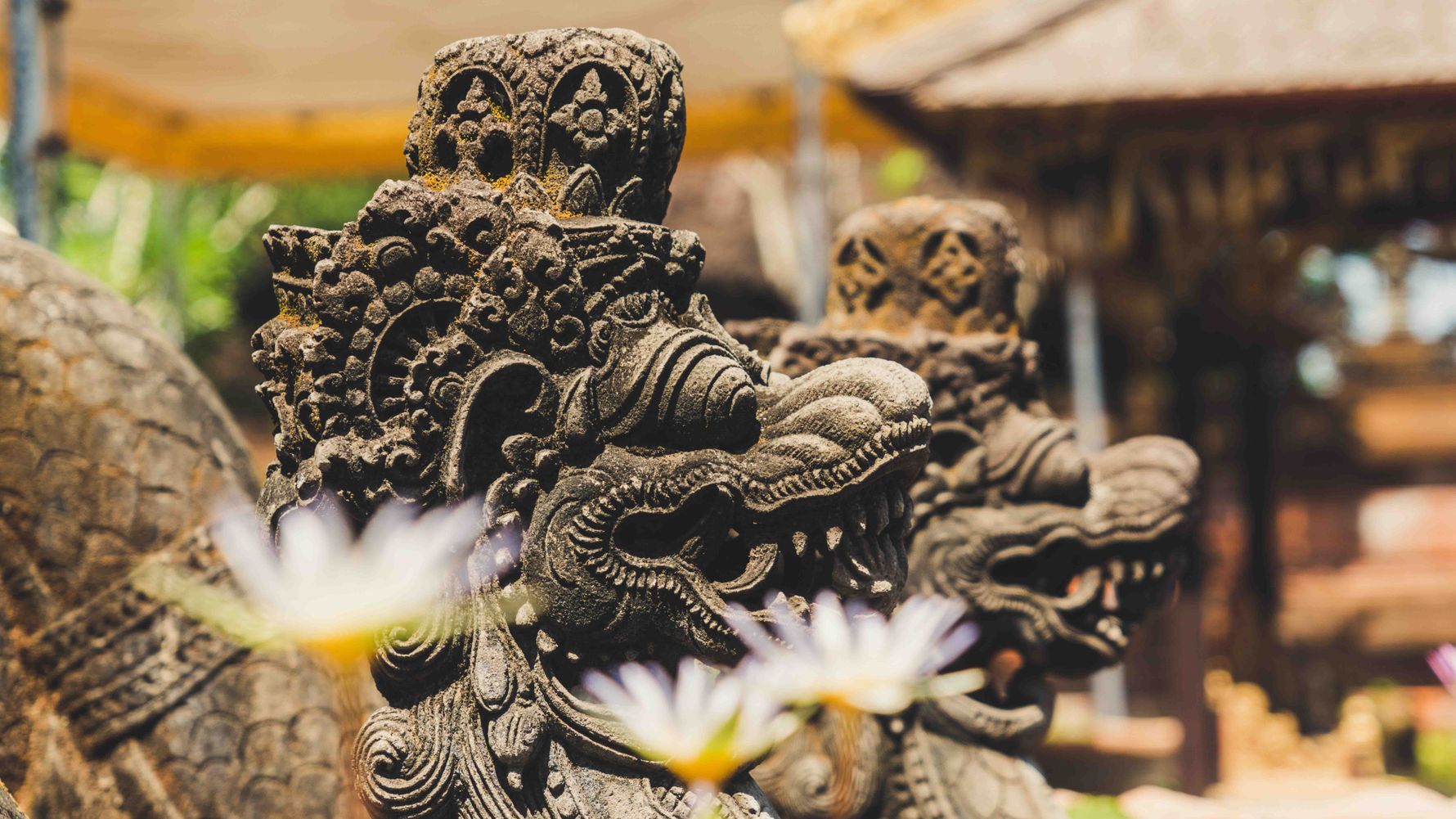 Zwei Staturen vor einem Tempel in Indonesien