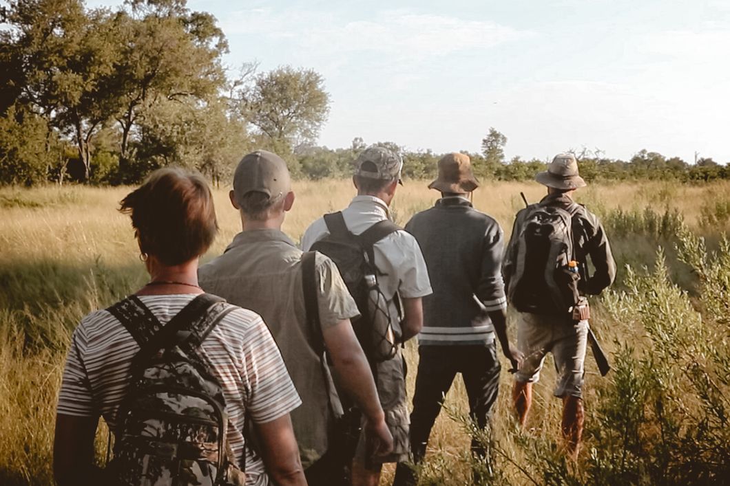 Ein Guide fuehrt seine Gruppe von angehenden Rangern durch den Busch Botswanas