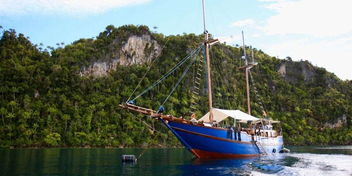 Das blaue Holzschiff des Segelt&ouml;rns mit zwei Masten vor der K&uuml;ste Indonesiens.
