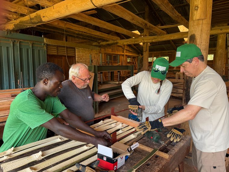 Four people in the workshop room are working with bamboo