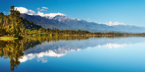 Das Wasser eines Neuseelaendischen Sees ist so klar und Flach das eine optimale Spiegelung der Berge im Hintergrund moeglich ist