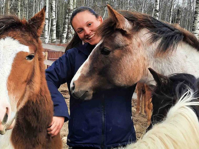 erfahrungsberichte-freiwilligenarbeit-kanada-pferdeschutz-lisa-natucate-volunteer-umgeben-von-pferden