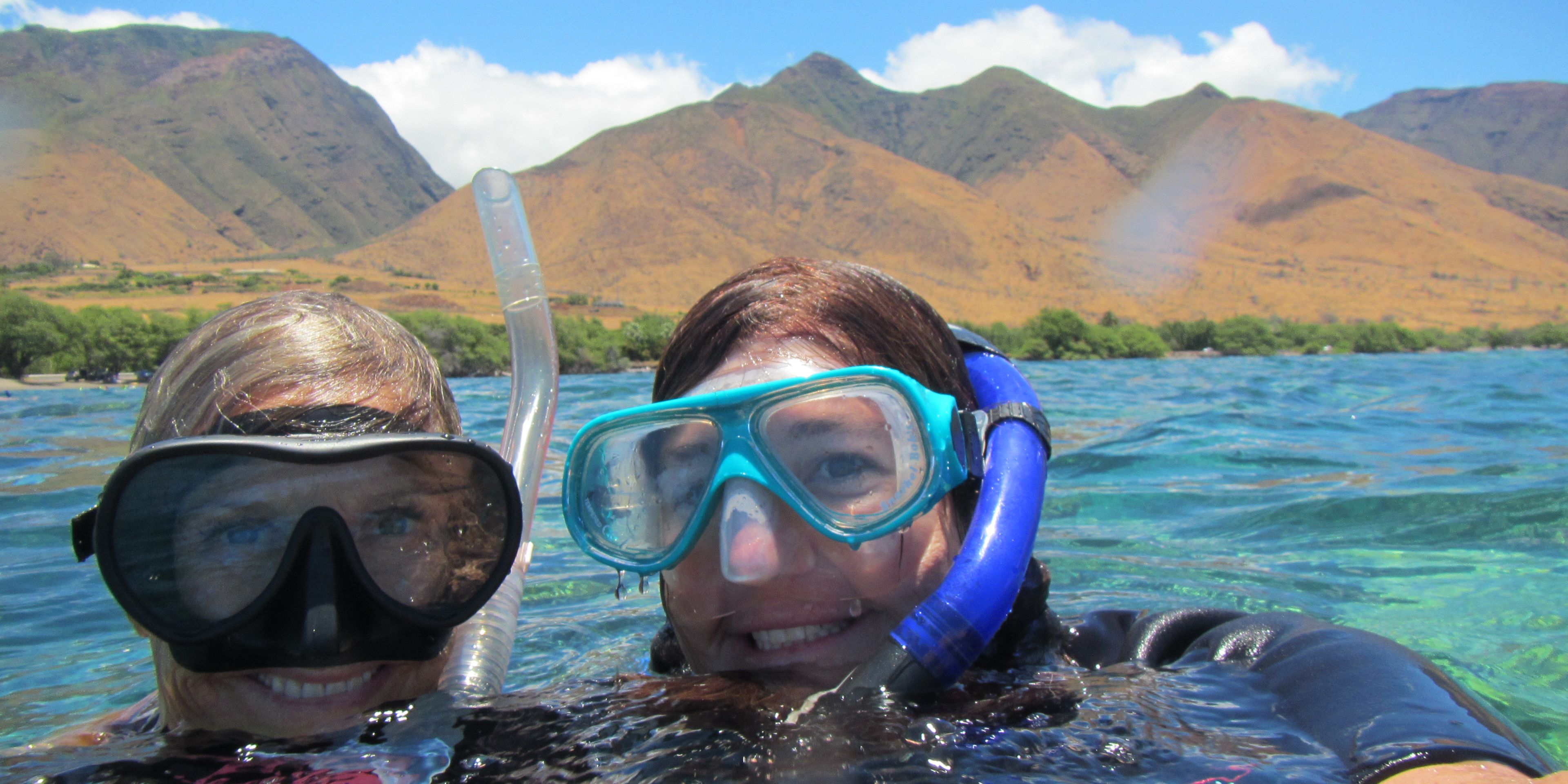 Two volunteers, equipped with snorkel and diving mask, in the waters off the Hawaiian coast
